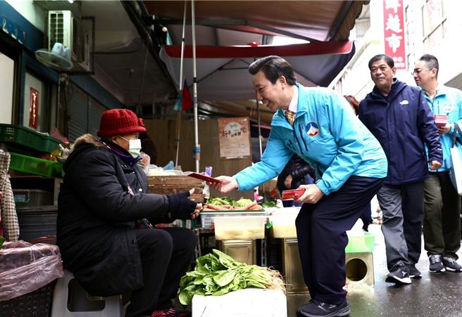 金门县长陈福海(右前)小年夜视察各传统市场，现场发送开运福袋，并向所有摊商与採买民眾拜年。(图／民眾提供)
