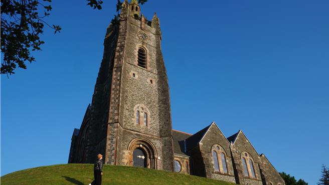 前进艾雷岛的前一晚，我们暂宿的Tarbert是个绝美小渔港，有着高耸塔尖的教堂是港湾小镇的信仰中心。夏令的日照时间很长，让我们有机会走在人群散去的如茵丘陵，近距离欣赏这古朴建筑的拔地参天。（王爵暐摄）