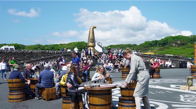 酒厂前的广场阳光普照，在这充满了音乐与觥筹交错的大家庭里，就算是来自自天涯海角的陌生人都能有一小处安身之地。（王爵暐摄）