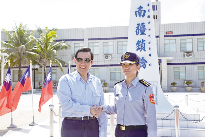 马英九总统（左）2016年1月28日，赴太平岛慰劳驻岛人员，并在「南疆锁钥」国碑前与海巡官兵合影。（军闻社提供）