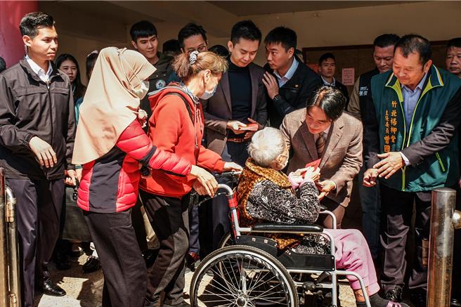 副總統、下屆總統當選人賴清德（右二）在竹北市陽柳堂發送福袋，先發給坐輪椅行動不便的老人家。（羅浚濱攝）