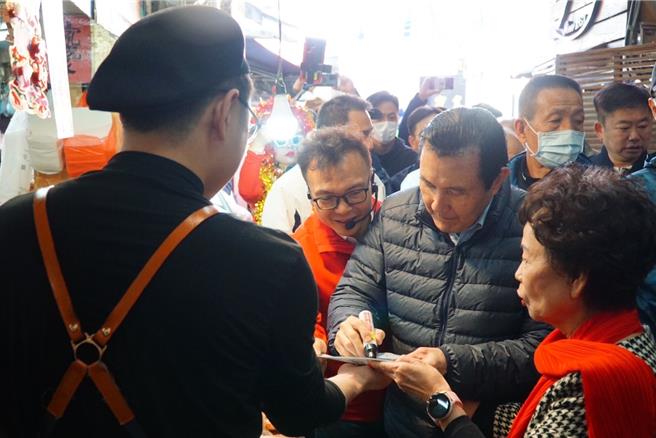 前总统马英九11日至新竹市城隍庙上香祈福，并亲自分送龙年红包袋给民眾，许多民眾主动要求与马英九合影与签名。（郑正钤团队提供／陈育贤新竹传真）