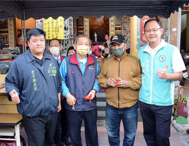 吳姓男子(右二)前一晚就來排隊，連續兩年搶頭香、領到屏東都城隍廟發財錢母。(林和生攝)