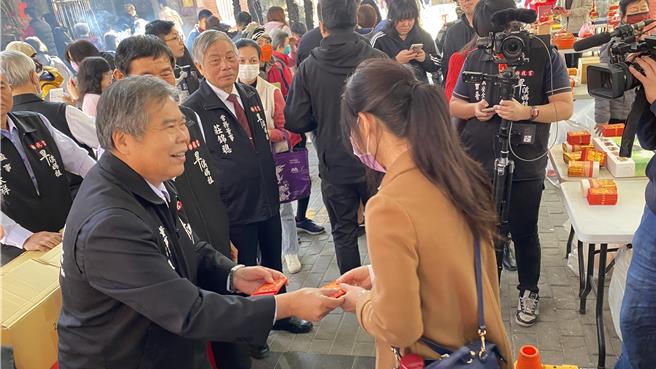 台中市東區樂成宮13日發放招財金大受歡迎，民眾大排長龍領取，董事長何敏誠（前排左）到場發放。（陳淑芬攝）