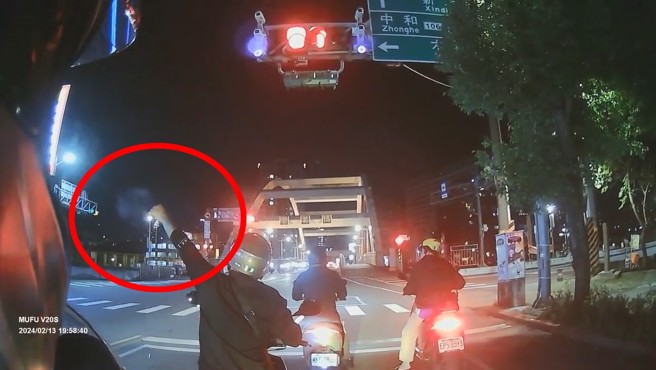 男騎士停等紅燈，前方騎士居然拿出沖天炮點燃。（翻攝爆料公社）