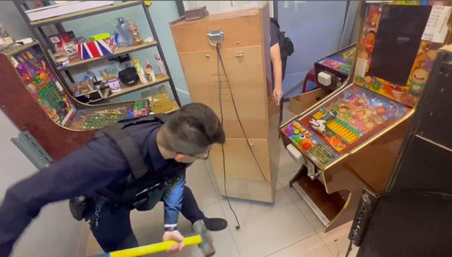 賭場負責人拒絕交出機台背板鑰匙，警方以鐵槌強制作為。（新北市三重警分局提供／呂健豪新北傳真）