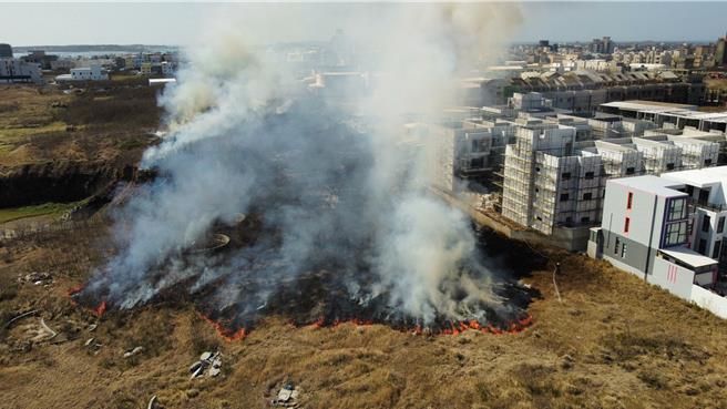 澎湖东卫水库集水区旁14日近午发生一起烧草火警，就在建筑工地旁，浓烟蔽天。（澎湖消防局提供／许逸民澎湖传真）