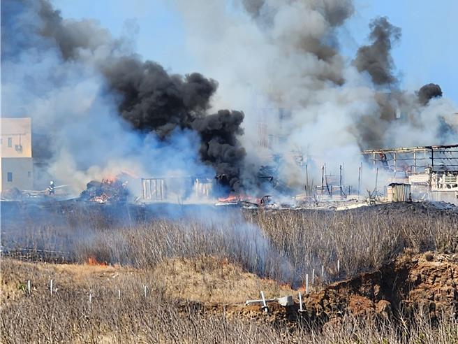 澎湖东卫水库集水区旁14日近午发生一起烧草火警，浓烟蔽天，大火也烧毁铁皮屋和货柜仓库。（许逸民摄）