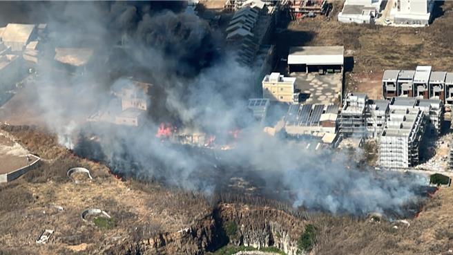 澎湖东卫水库集水区旁14日近午发生一起烧草火警，浓烟蔽天，图为空拍可见大火也烧毁铁皮屋和货柜仓库。（罗盘提供／许逸民澎湖传真）