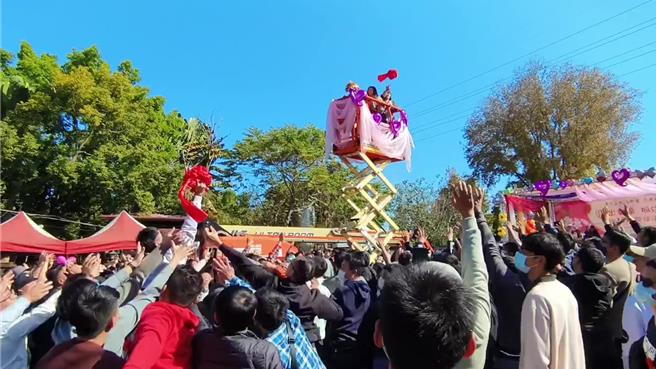 嘉义市大福兴宫月老祖庙今天举办高空抛绣球，男性纷纷高举双手抢球，场面热烈。（廖素慧摄）
