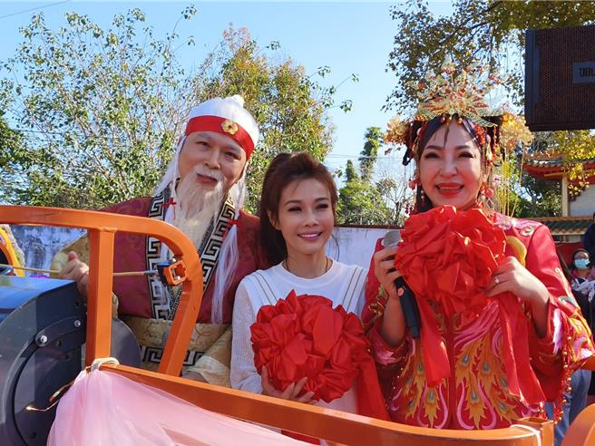 歌手董育君、艺人扮演月老公公、月老婆婆搭高空作业车示范从高空抛绣球。（廖素慧摄）