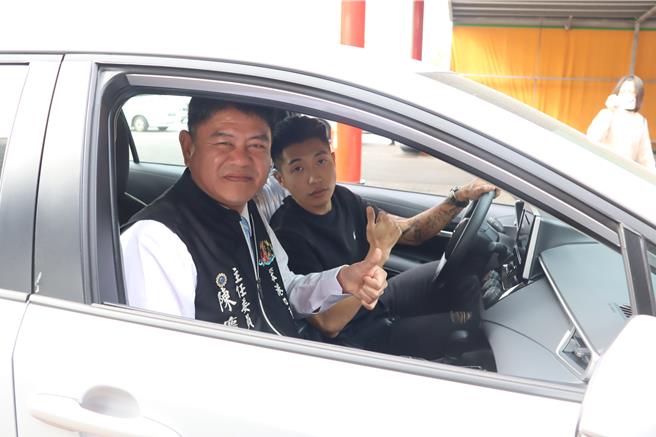 庄棋渊以10筊胜出获得80万轿车后，由主委陈庆堂陪同开车在庙前绕一圈。（吕妍庭摄）