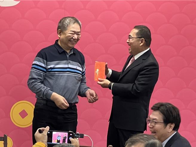 侯友宜開心收到蔣根煌的紅包。（王揚傑攝）