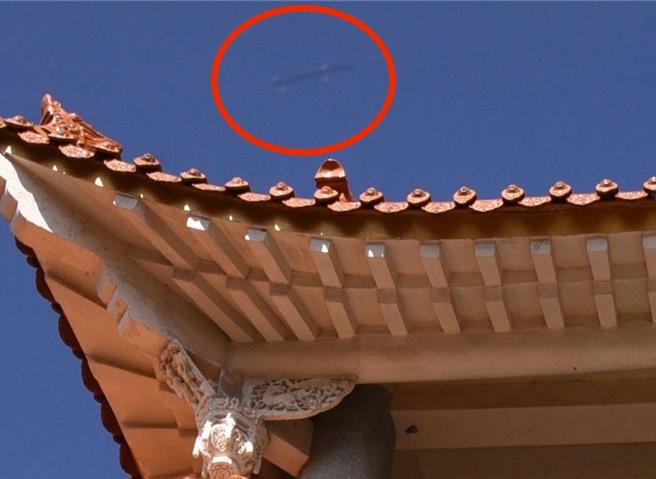 湯姓業餘攝影師14日前往後龍鎮龍坑里的無極聖宮拍攝宮門時意外拍獲疑似巡弋飛彈的不明飛行器（紅圈處）。（讀者提供／謝明俊苗栗傳真）