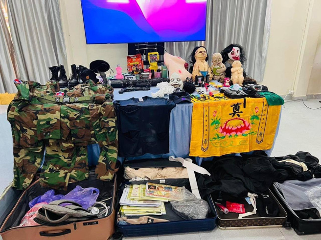 柬埔寨警方记者会现场摆放了搜出的鬼娃面具。（图／柬埔寨警方提供）