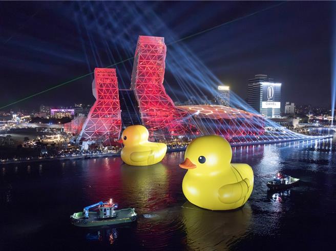 春节期间黄色小鸭搭配高雄流行音乐中心红色灯光。（高市观光局提供）