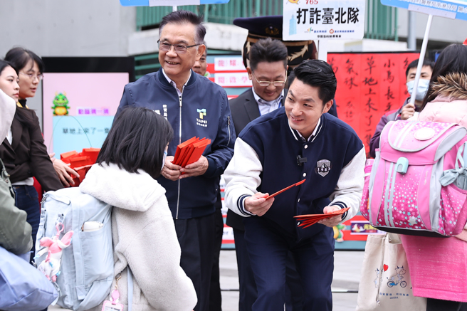 台北市長蔣萬安（右）16日由教育局長湯志民（左）陪同前往南港區東新國小發送紅包給上學的學生。（羅永銘攝）