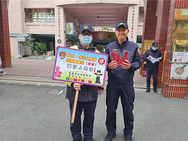 芦竹员警手持交通安全宣导标语，针对「路口不停让、行人违规」加强宣导。（桃园市芦竹警分局提供／陈梦茹桃园传真）