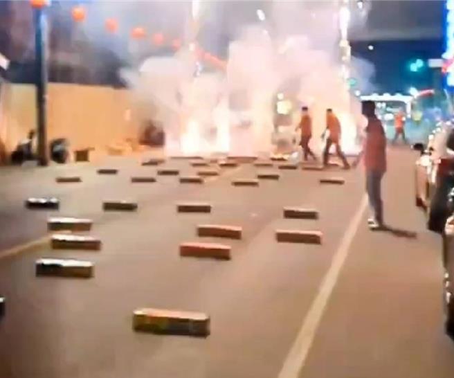 屏东县崁顶乡北院庙15日举办庙会遶境，虽有事先申请核准路权，但却占用道路放鞭炮逾10分钟，吓得路边女骑士躲在车后拿纸箱罩住头。（翻摄社会事新闻影音／谢佳潾屏东传真）