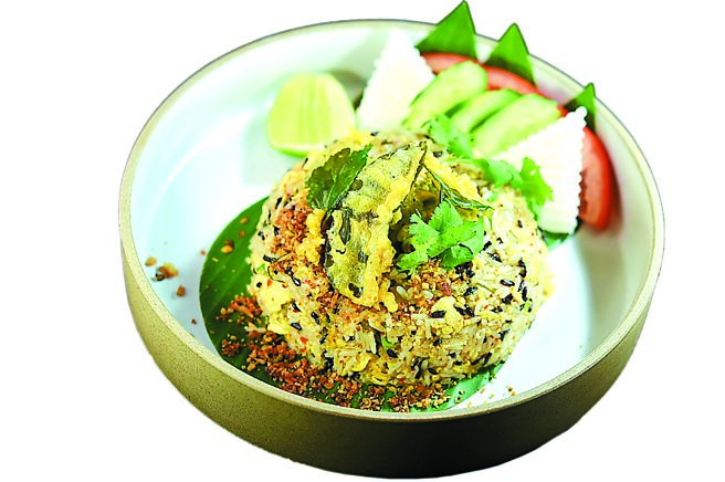 〈伊善三米松阪豬炒飯 〉用了黑、白糯米及泰國香米三種米，與北蔥、洋蔥、新鮮香茅、香菜、辣椒粉及自製米粉等調製醬汁，加入松阪豬翻炒，起鍋再撒上主廚自製魚酥鬆，口感獨特香氣逼人。圖／姚舜