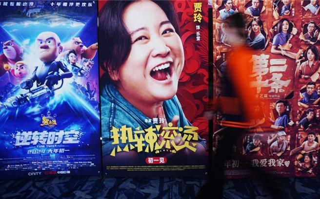 大陆2024年长达8天的春节檔期总票房粗报新台币353亿元，刷新纪录。图为观眾从浙江杭州一家影院的春节檔电影海报前走过。（新华社资料照片）