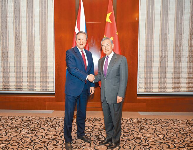 中共中央政治局委员、大陆外长王毅（右）在出席慕尼黑安全会议期间，应约会见英国外相卡麦隆（左）。（新华社）