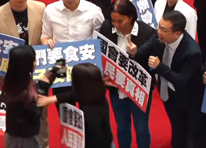 黄捷（左）试图抢走罗智强（右）的麦克风，被徐巧芯（中）阻止。（图 / 撷取自中时直播）