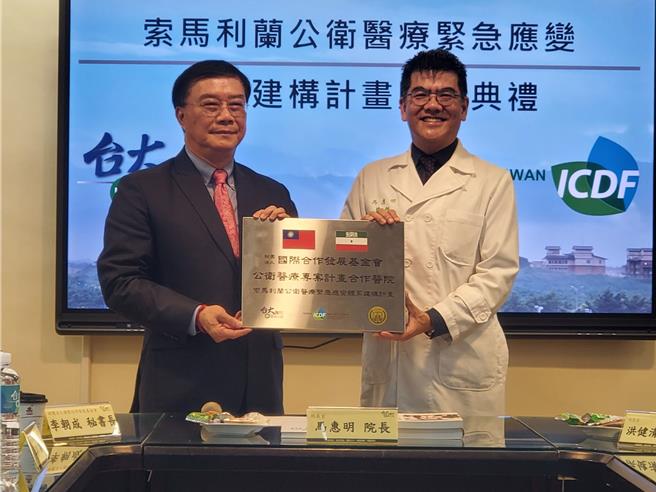 財團法人國合會祕書長李朝成（左）20日贈牌給台大雲林分院，由院長馬惠明代表接受。（周麗蘭攝）