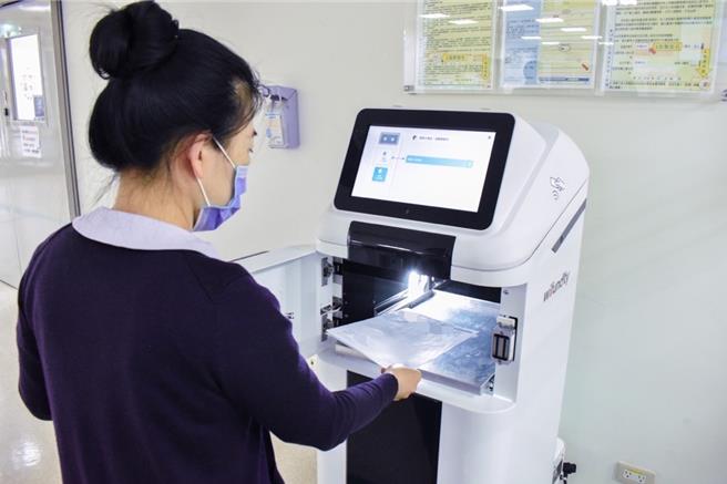 急诊护理人员使用识别证开启Wifundity智能服务型机器人，放置处方笺后由机器人精准且快速配用。（新竹台大分院提供／邱立雅竹县传真）