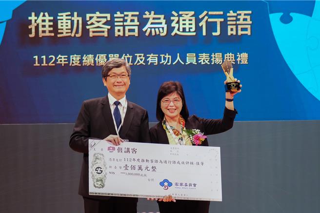 新竹县积极推动客语为通行语，在客委会112年度客语评核挥出「全垒打」，客委会主委杨长镇（左）在21日表扬典礼颁发奖牌和奖金给县府秘书长李安妤（右），竹县共获颁1290万元奖励金创下新高。（新竹县政府提供／罗浚滨新竹传真）