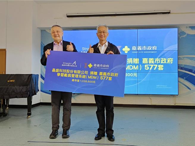 嘉义市政府教育处长郭添财（右）今天代表接受晶盛科技总经理程应龙捐赠MDM。（廖素慧摄）