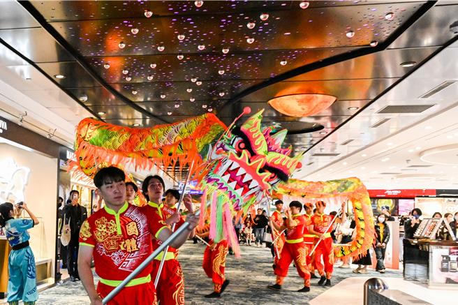 采盟免税店特别邀请国立体育大学舞龙队14位师生快闪演出，巨龙全长18公尺重达16公斤穿梭于二航厦采盟免税商店及登机长廊间，演绎龙腾天下、飞龙登天的风采，展现传统节庆的欢乐喜悦与动感魅力。（陈麒全摄）