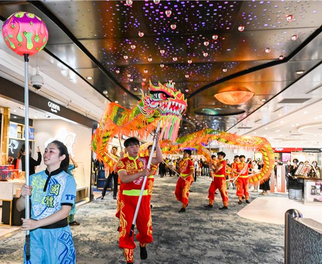 采盟免税店特别邀请国立体育大学舞龙队14位师生快闪演出，巨龙全长18公尺重达16公斤穿梭于二航厦采盟免税商店及登机长廊间，演绎龙腾天下、飞龙登天的风采，展现传统节庆的欢乐喜悦与动感魅力。（陈麒全摄）