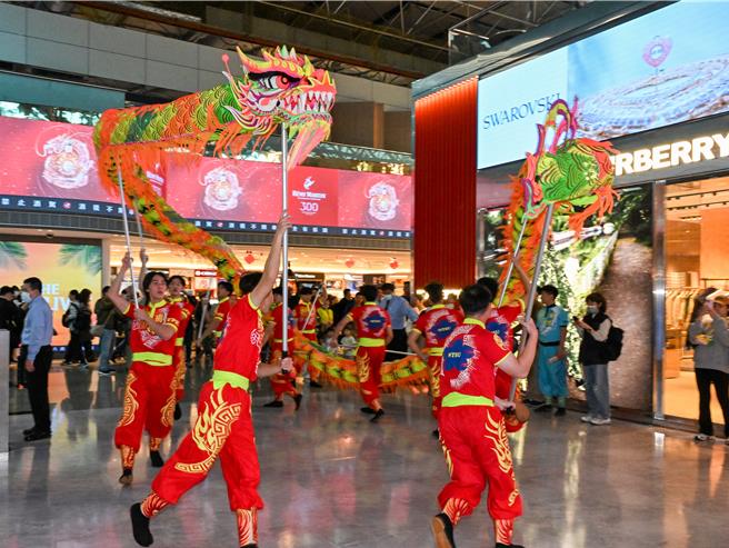 采盟免税店特别邀请国立体育大学舞龙队14位师生快闪演出，巨龙全长18公尺重达16公斤穿梭于二航厦采盟免税商店及登机长廊间，演绎龙腾天下、飞龙登天的风采，展现传统节庆的欢乐喜悦与动感魅力。（陈麒全摄）