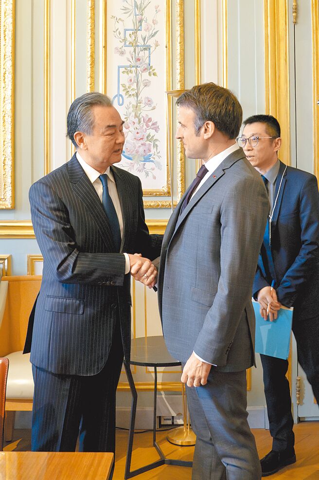 當地時間2月20日，法國總統馬克宏（右）在巴黎會見來訪的中共中央政治局委員、中央外辦主任王毅（左）。（新華社）