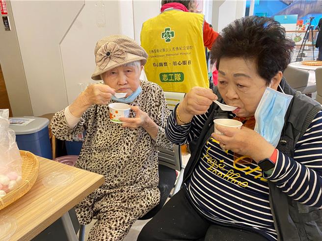 93岁的林阿嬷（左）23日参加彰化市秀传医院摇元宵活动时吃小汤圆，并提醒大家要小心，不要噎到。（秀传医院提供／孙英哲彰化传真）