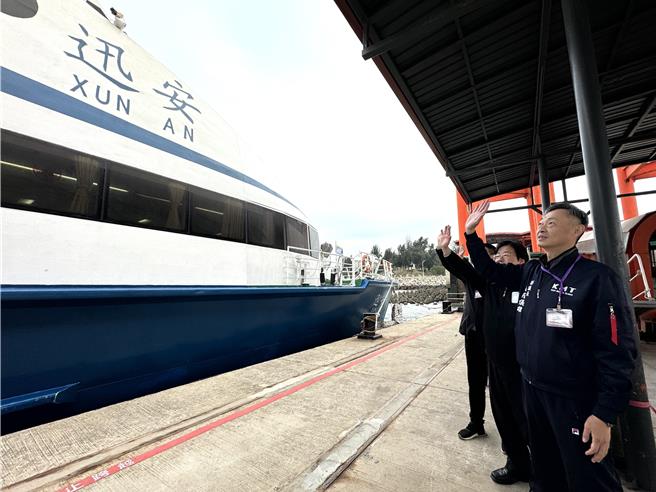 县议会副议长欧阳仪雄(前)等人完成送行后，也在船边向陆方代表及家属挥手致意。（于家麒摄）