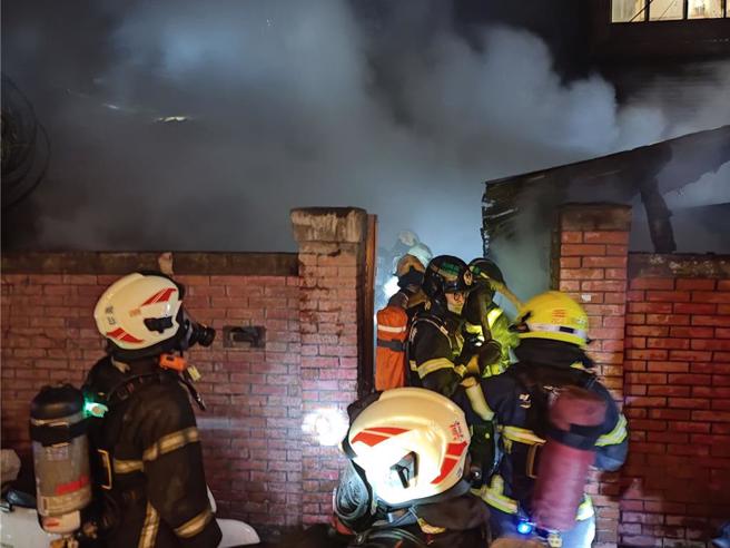 台南市中西区法华里一栋红砖老宅23日晚间6时许发生火警，消防人员到场灌救，现场白烟瀰漫。（读者提供／程炳璋台南传真）