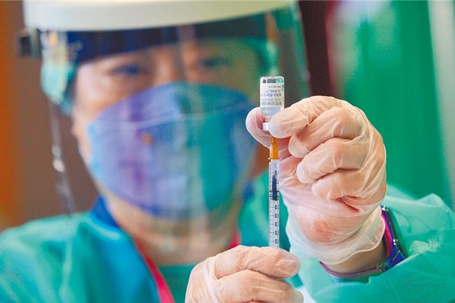 图为医护人员用针管抽取BNT疫苗。（张铠乙摄）