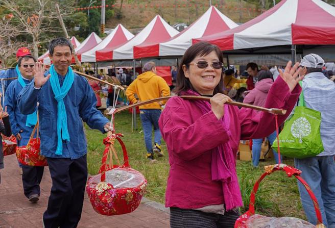 新竹县宝山乡24日举办客家庆典「打中午文化季」活动，乡公所邀集乡内各村邻长及社区发展协会共同挑担，超过200担以上的奉饭美食。（罗浚滨摄）