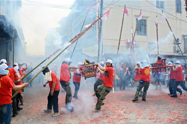 全台唯一保留客家竹竿炮傳統的屏東市林仔內三山國王廟，信徒們24日將竹竿綁上鞭炮，衝炸神轎趨吉避凶。（林和生攝）