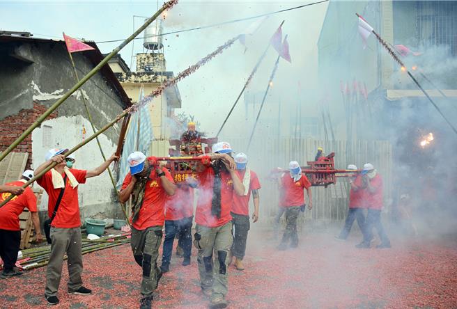 全台唯一保留客家竹竿炮傳統的屏東市林仔內三山國王廟，信徒們24日將竹竿綁上鞭炮，衝炸神轎趨吉避凶。（林和生攝）