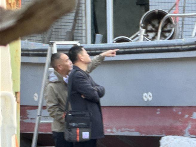 泉州台办副主任李朝晖(左)与晋江红十字会秘书长曹荣山(右)也仔细观察翻覆渔船之外观，查看有无可疑之处。(于家麒摄)