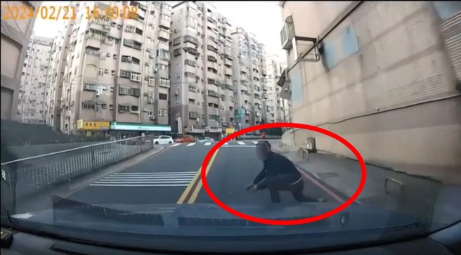 一名碰瓷男子選在上坡處，看到車子靠近就直接撲倒路中，被批評演技超差。（翻攝爆料公社）