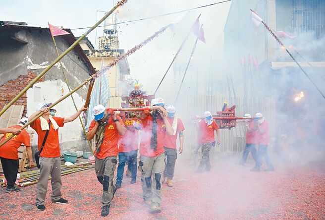 屏東市林仔內三山國王廟，信徒們24日將竹竿綁上鞭炮，衝炸神轎趨吉避凶。（林和生攝）