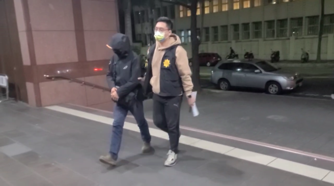 「國寶集團」總裁朱國榮捨棄5億交保金，於去年9月搭乘遊艇潛逃成功，隨後遭通緝，而協助他潛逃的極致租賃公司負責人周哲男等人已向檢警自首。台北地檢署檢察官顏伯融今指揮刑事局、信義分局、海巡署偵防分署兵分5路搜索，預計訊問鍾姓船長等9名被告。圖為鍾姓船長晚間移送檢方。（截取自影片）