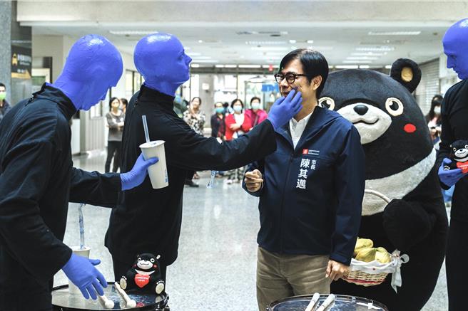 百老匯最幽默喜劇「藍人樂團」以全新節奏再度登台，今（27）日藍人在下班時段，突襲高雄市政府，攔截高雄市長陳其邁，摸了摸市長的臉蛋。（寬宏藝術提供）