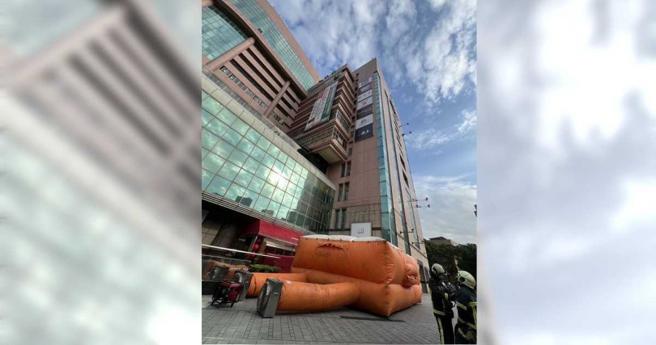 警消紧急架设软气垫，最终成功将女子劝下，不过女子被劝下时却被发现其外套内还穿了一件医师袍。（图／民眾提供）