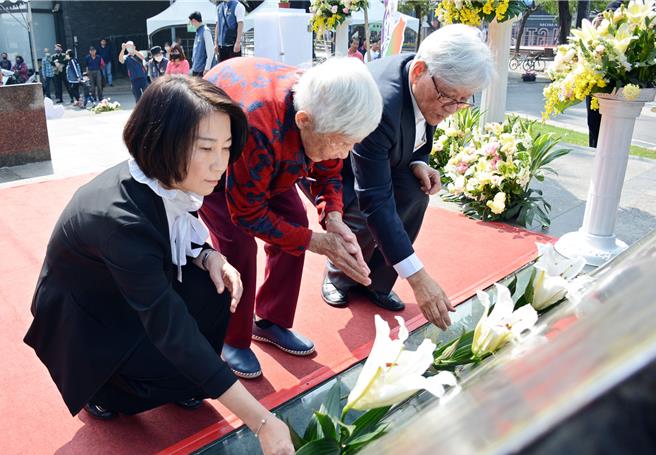屏東縣長周春米(左)向228受難者先賢致上最崇高敬意，並與罹難者家屬一同向紀念碑獻花。(林和生攝)