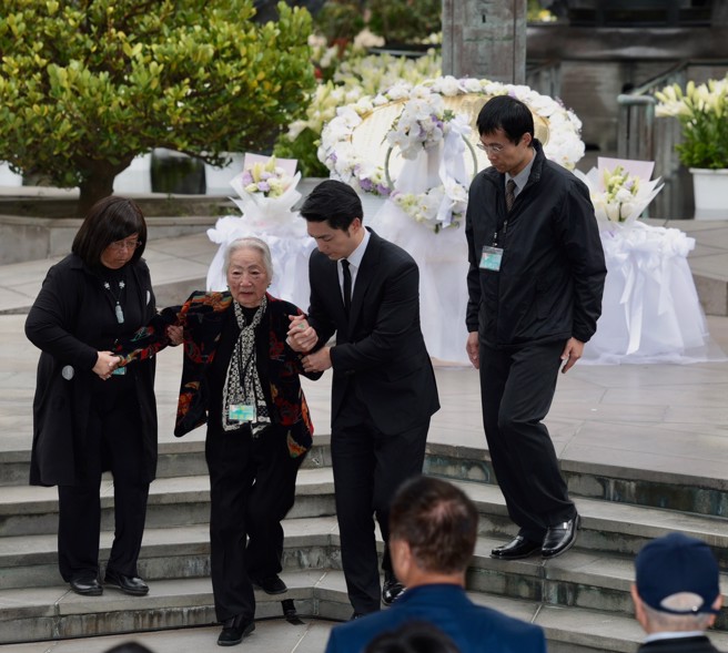 台北市长蒋万安（中右）28日出席二二八事件77周年追思会，蒋献花后搀扶二二八事件受难亲属回座。（郭吉铨摄）